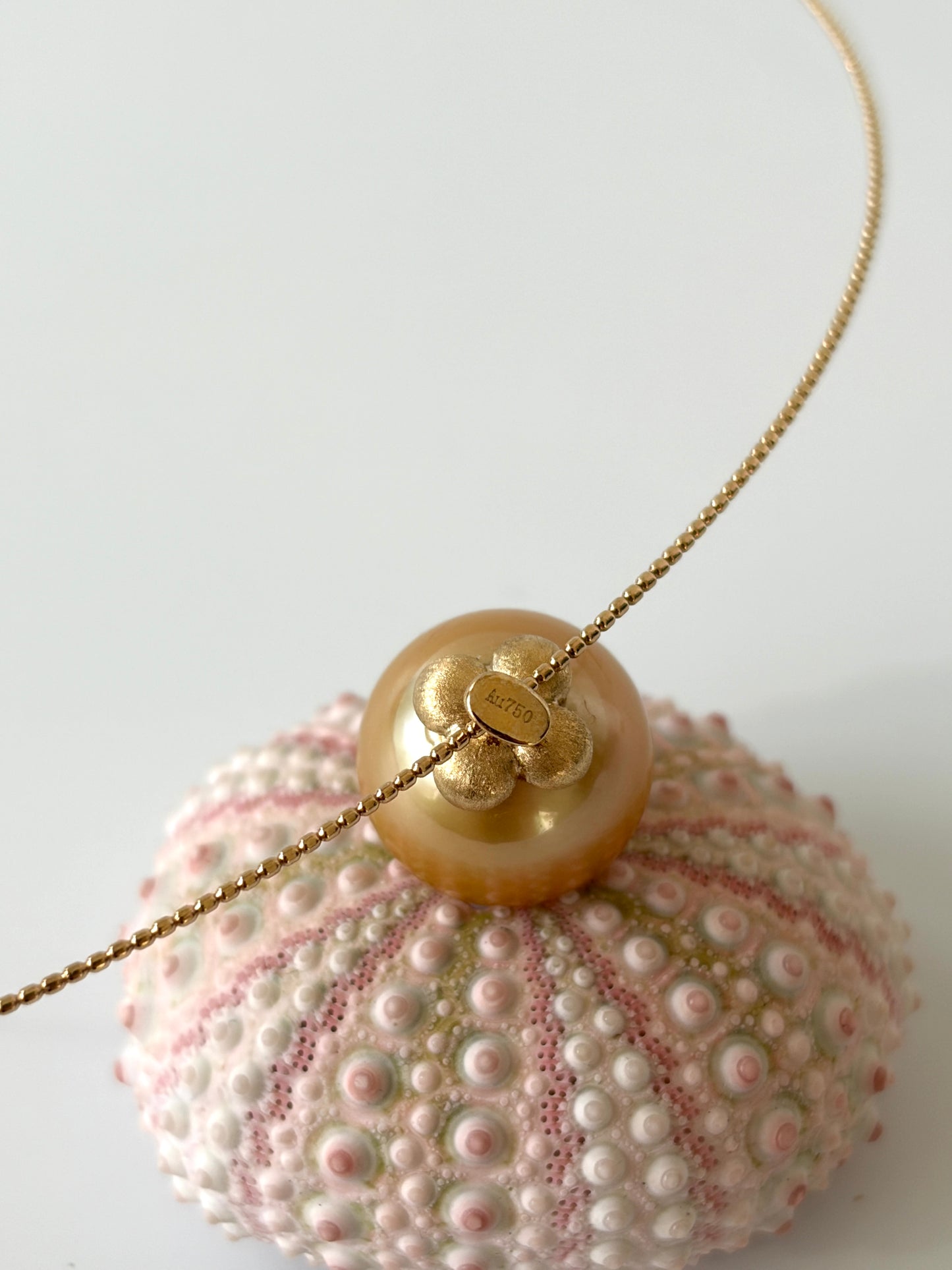 Necklace with a large south sea golden pearl pendant on a white background marked with AU 750