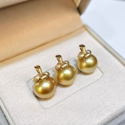 Three south sea golden pearl pendants on a soft white surface