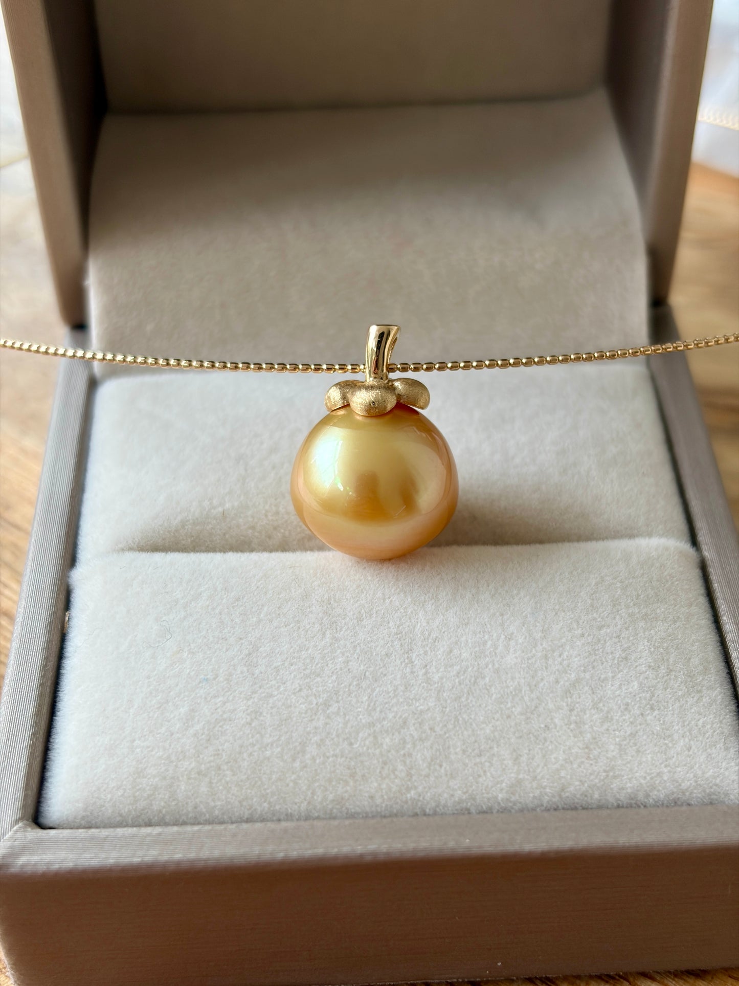 South Sea golden pearl pendant in an open jewelry box.