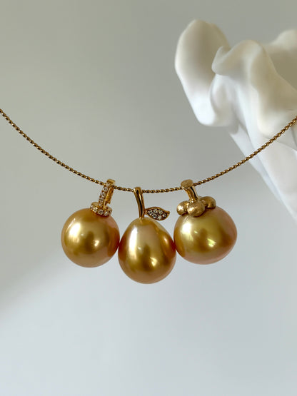 three south sea golden pearl pendants on a white background