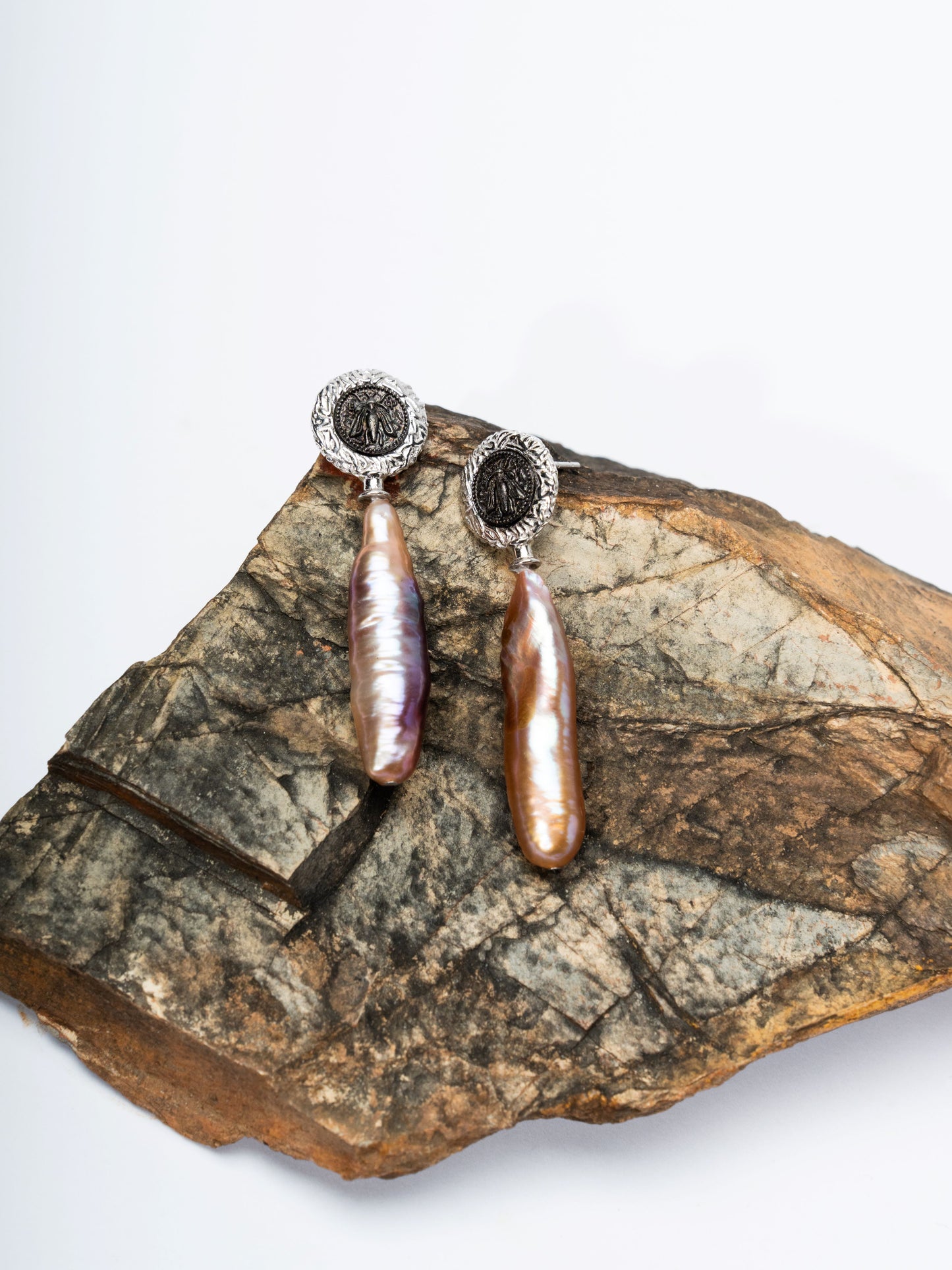 Pair of pearl earrings on a piece of stone