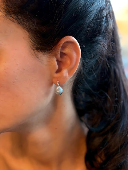 Close-up of women wearing a Tahitian Keshi pearl earrings with blurred background