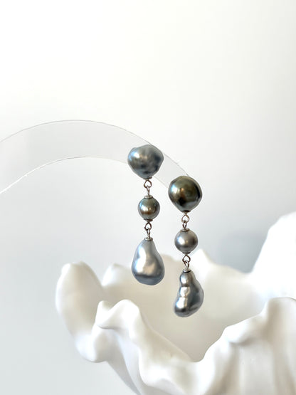 Pair of silver Tahitian Keshi Baroque pearl earrings on a white background