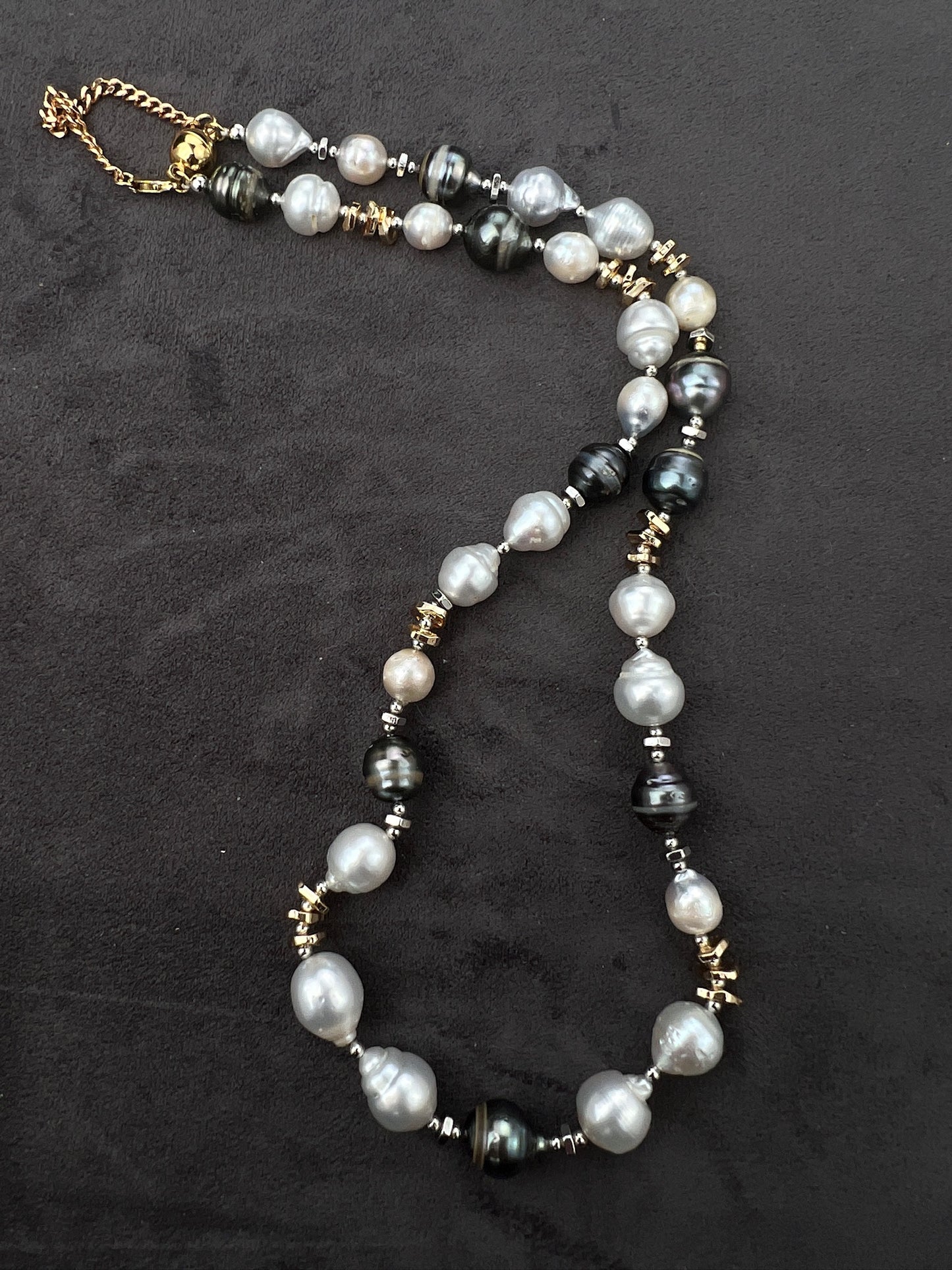 Necklace with Tahitian and South Sear pearls and gold accents on a dark background