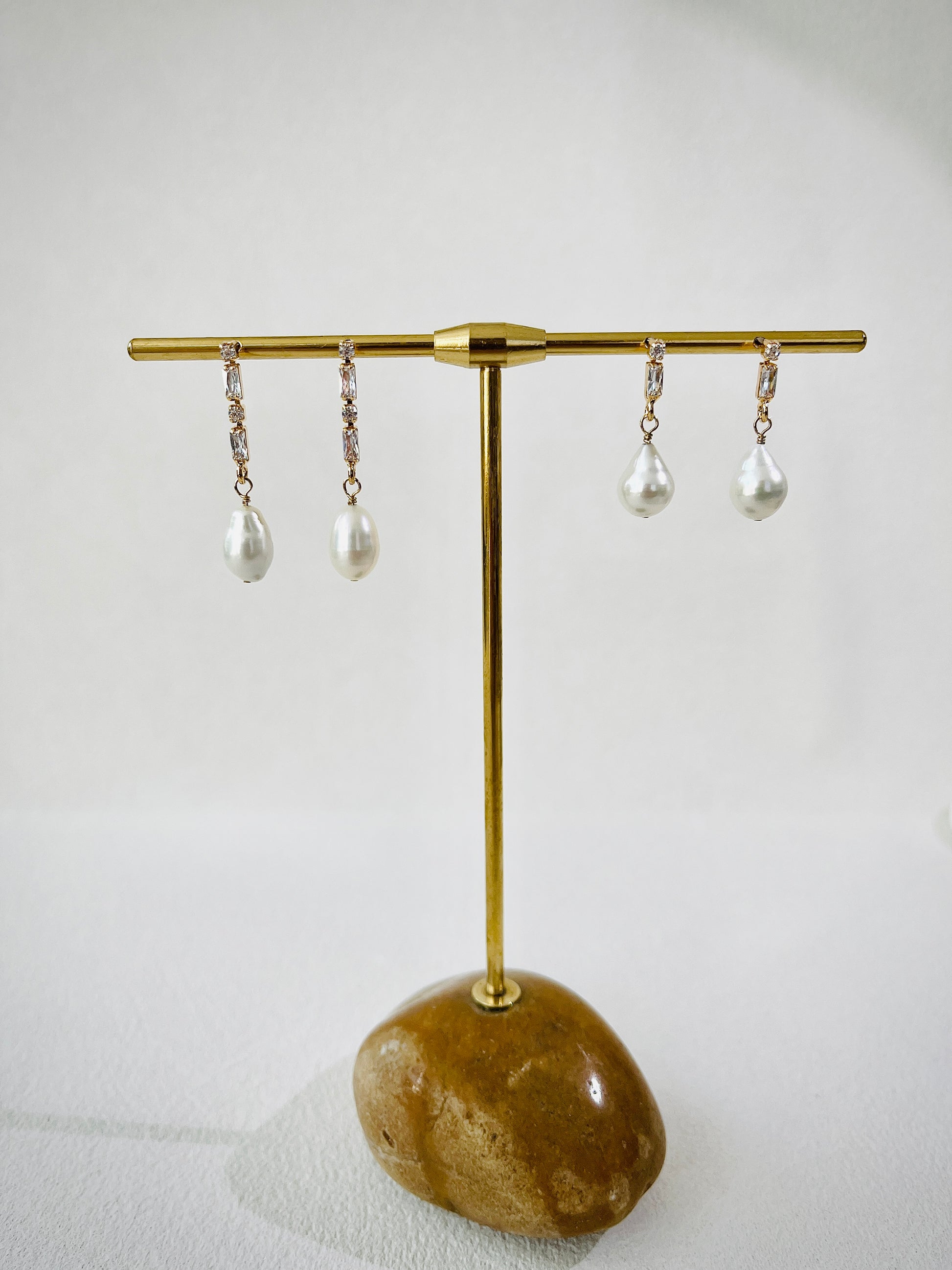 Pearl earrings with gold zircon stud on a white background