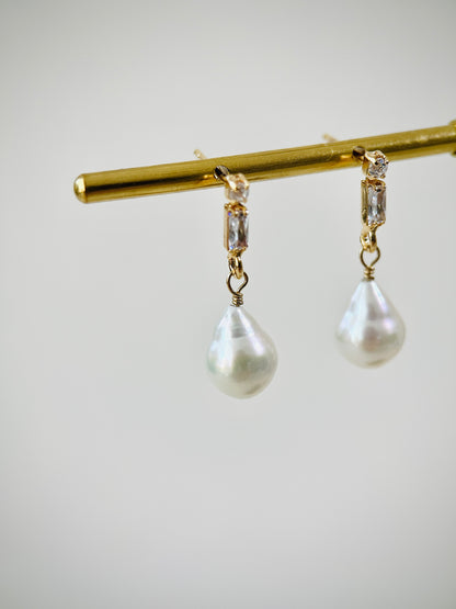 Pearl earrings with gold zircon stud on a white background