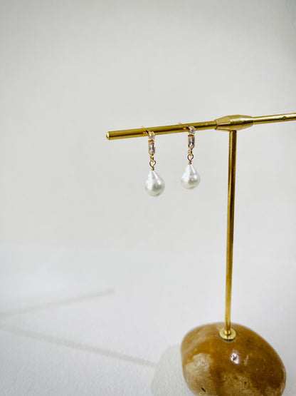 Pearl earrings with gold zircon stud on a white background