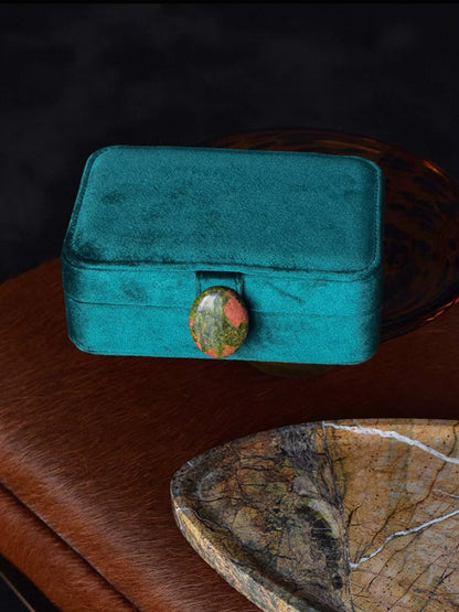 Caribbean Turquoise velvet jewelry box with a decorative stone on a natural surface