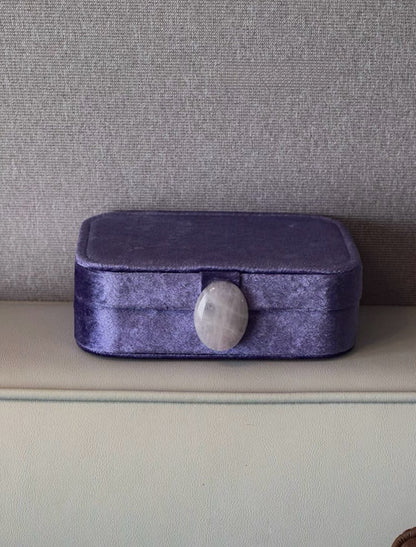 Iris purple velvet jewelry box with a gray stone on a neutral background