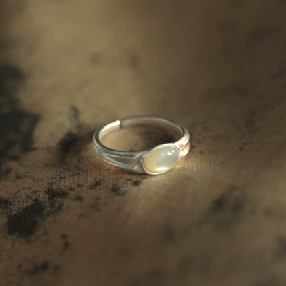 Silver ring with a stone on a textured brown surface