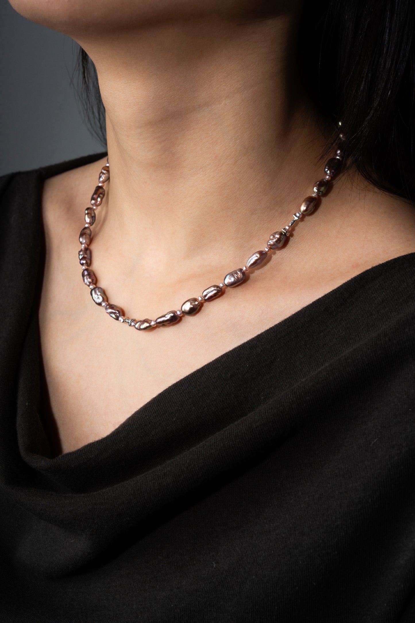 Keshi pearl necklace worn by a person against a black background