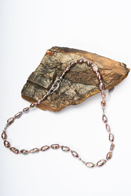 Necklace with pink Keshi pearls on a rock