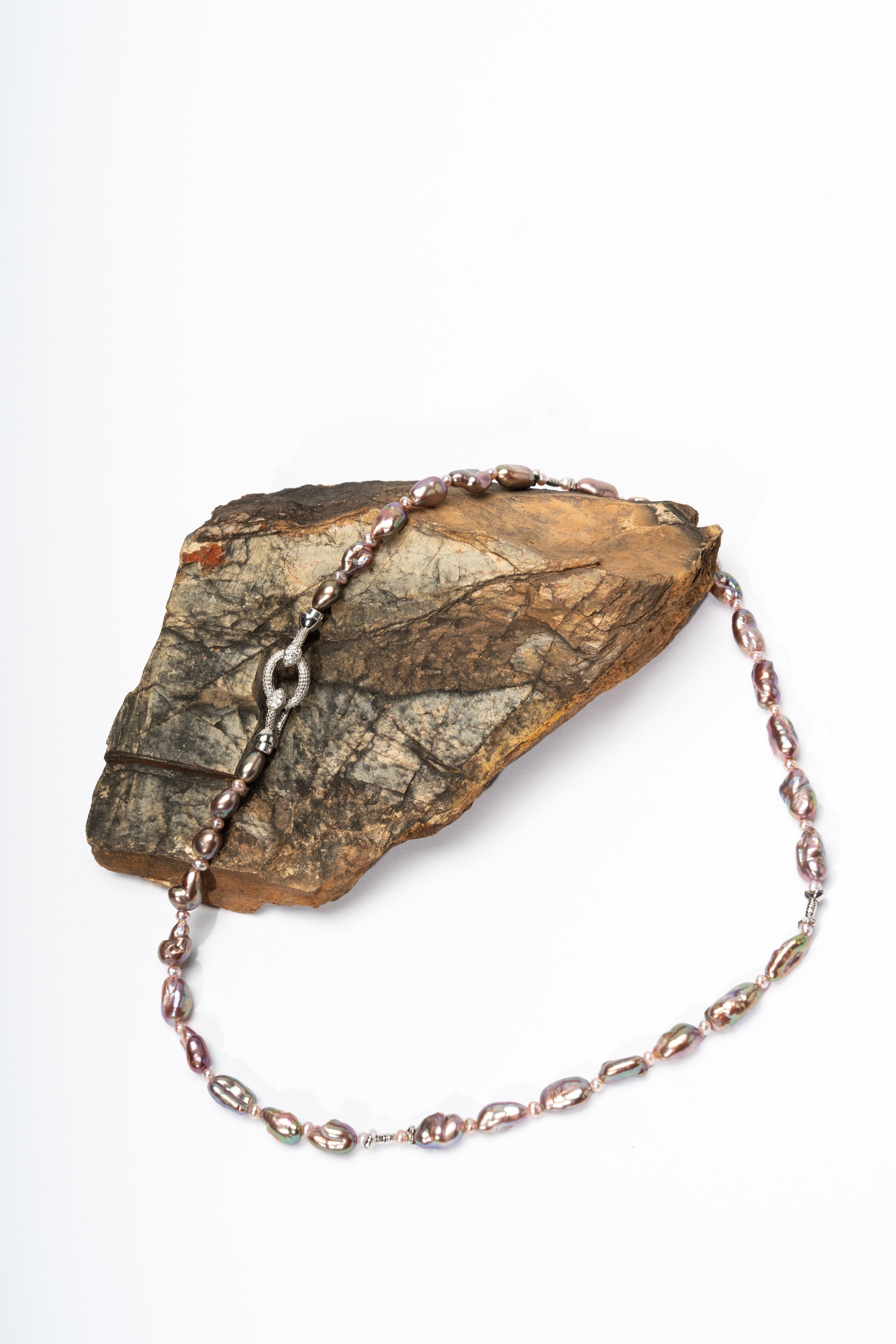 Keshi pearl bracelet with silver chain on a stone surface