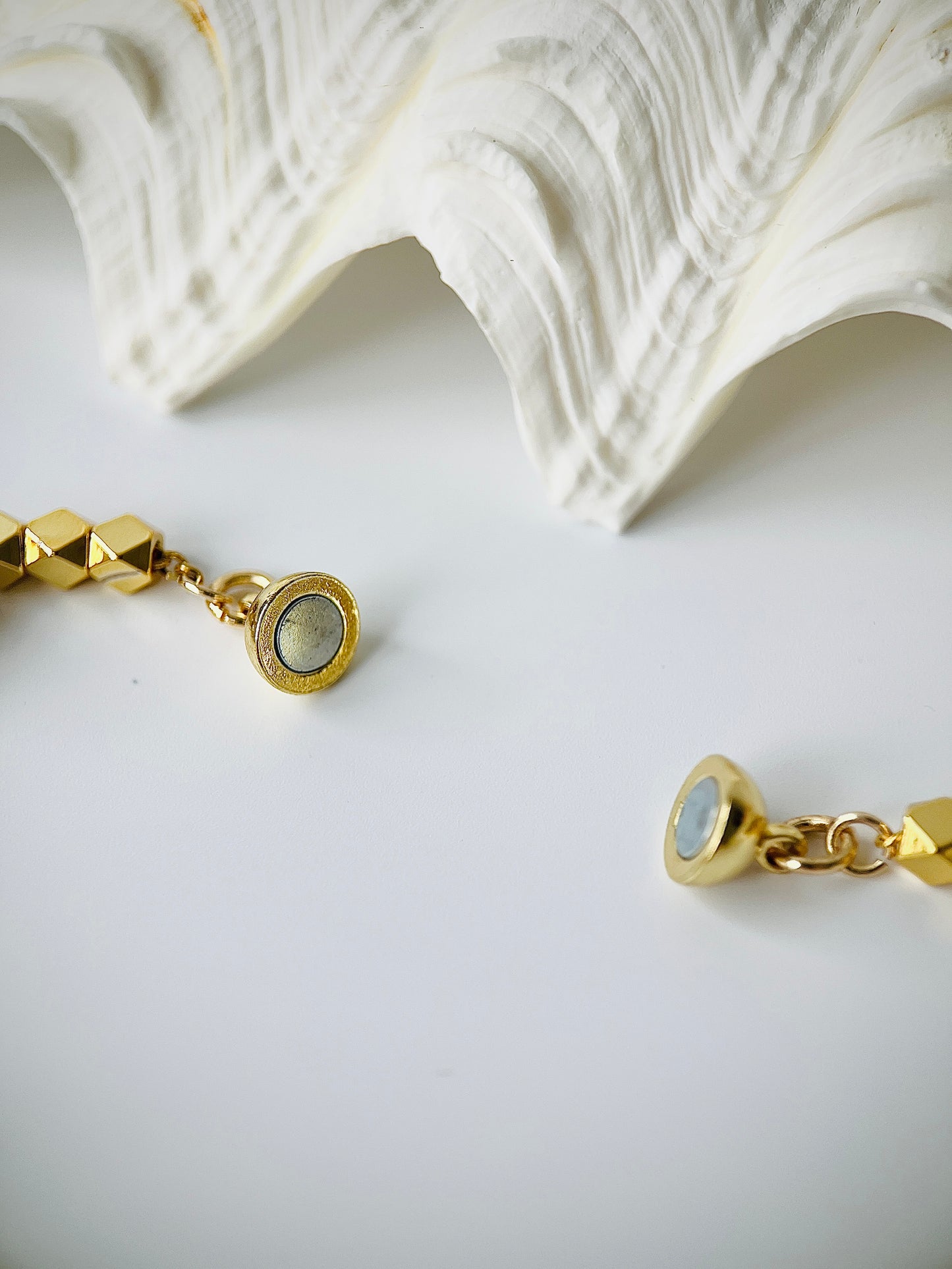 Gold pearl bracelet with a magnetic clasp on a white surface