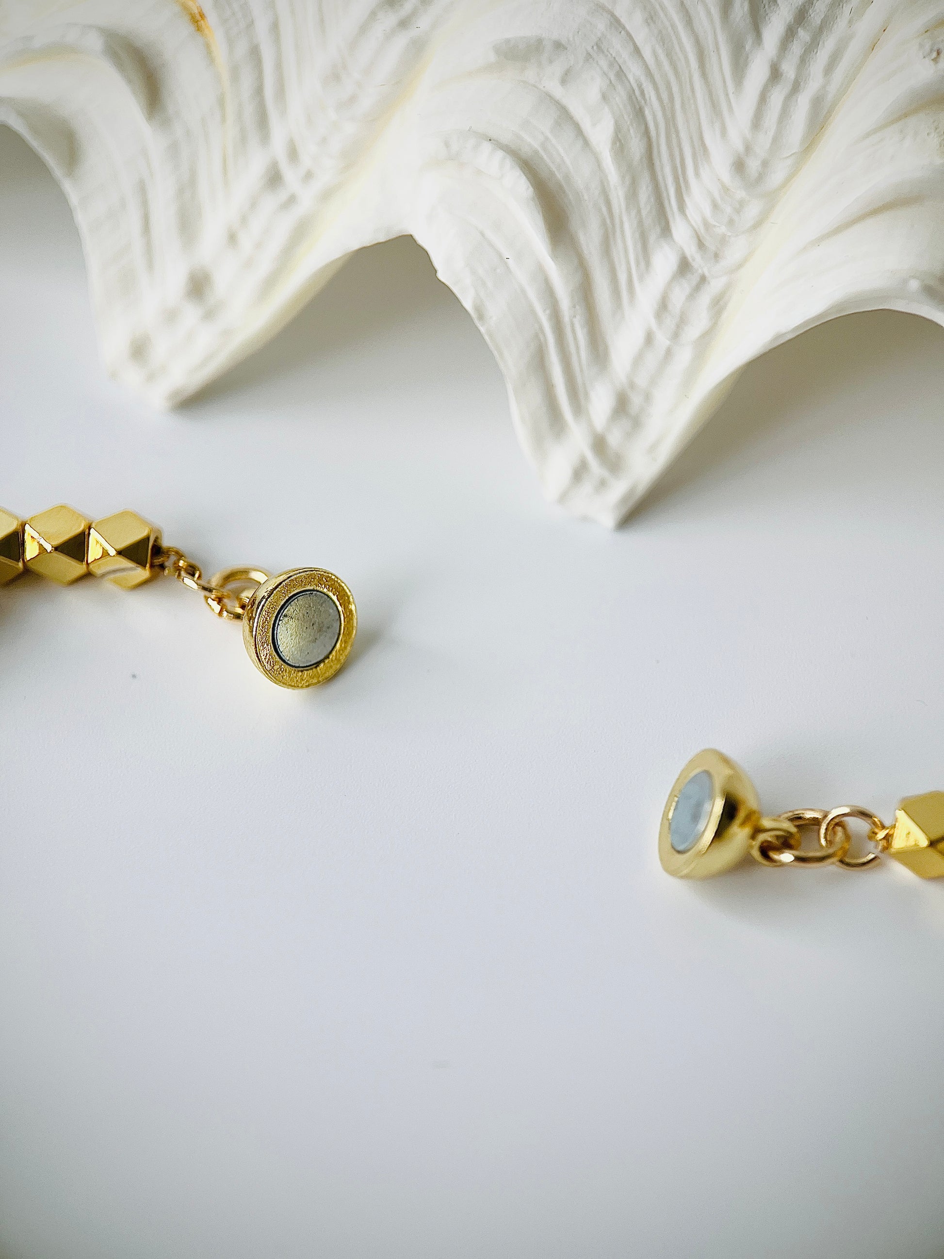 Gold pearl bracelet with a magnetic clasp on a white surface
