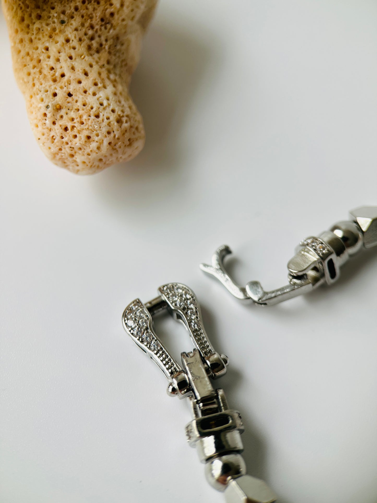 Close-up of silver jewelry clasp of a pearl bracelet on a light background