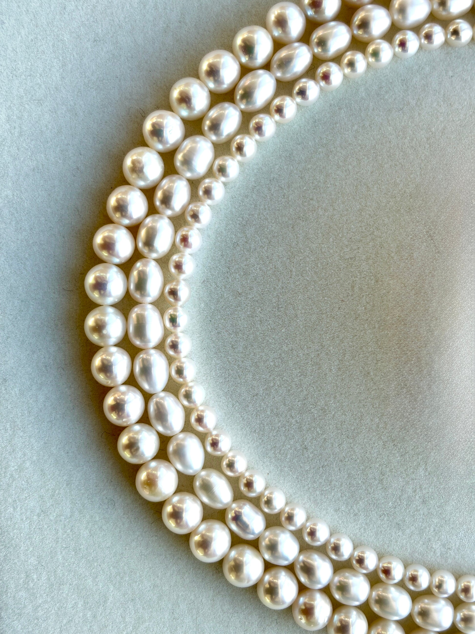 Close-up of a string of pearls on a light blue background