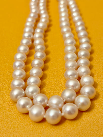 pearl strand of white pearls on a yellow background
