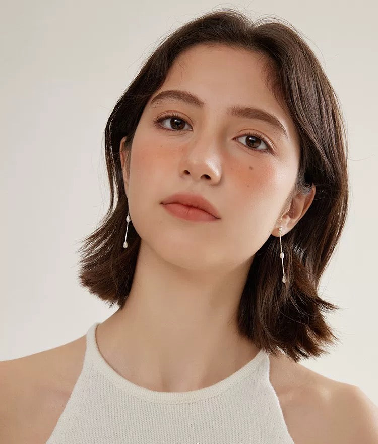 White Freshwater Pearl Chandelier Earrings worn by a model with short hair, showcasing their elegant design and aesthetic appeal.