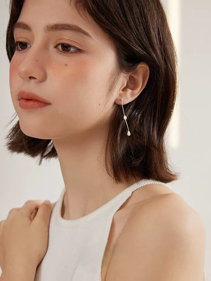 White Freshwater Pearl Chandelier Earrings worn by a model with short brown hair, showcasing elegance and style.