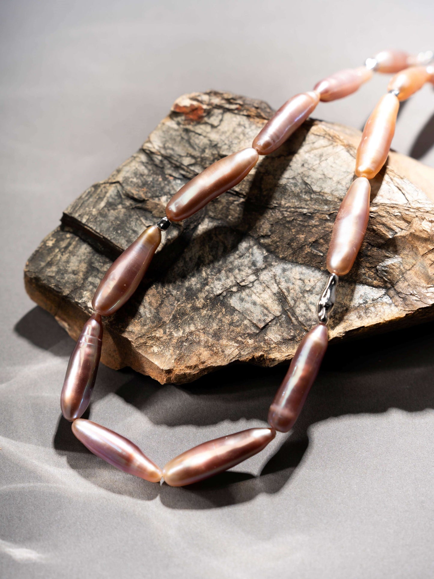 Pearl Necklace with brown beads on a stone surface