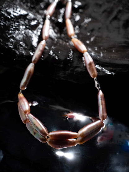 Pearl Necklace with brown and white beads on a dark background