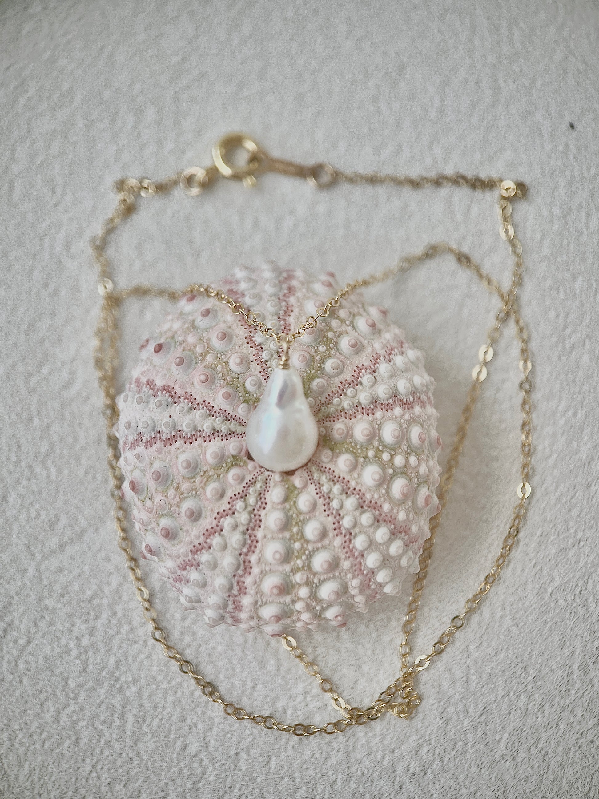 Pearl Necklace with a pendant on a textured surface