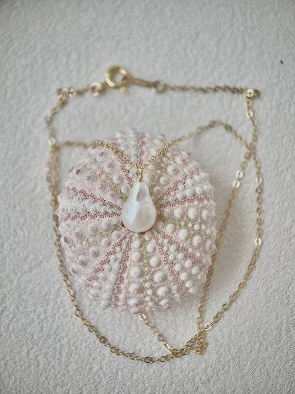 Pearl Necklace with a pendant on a textured surface