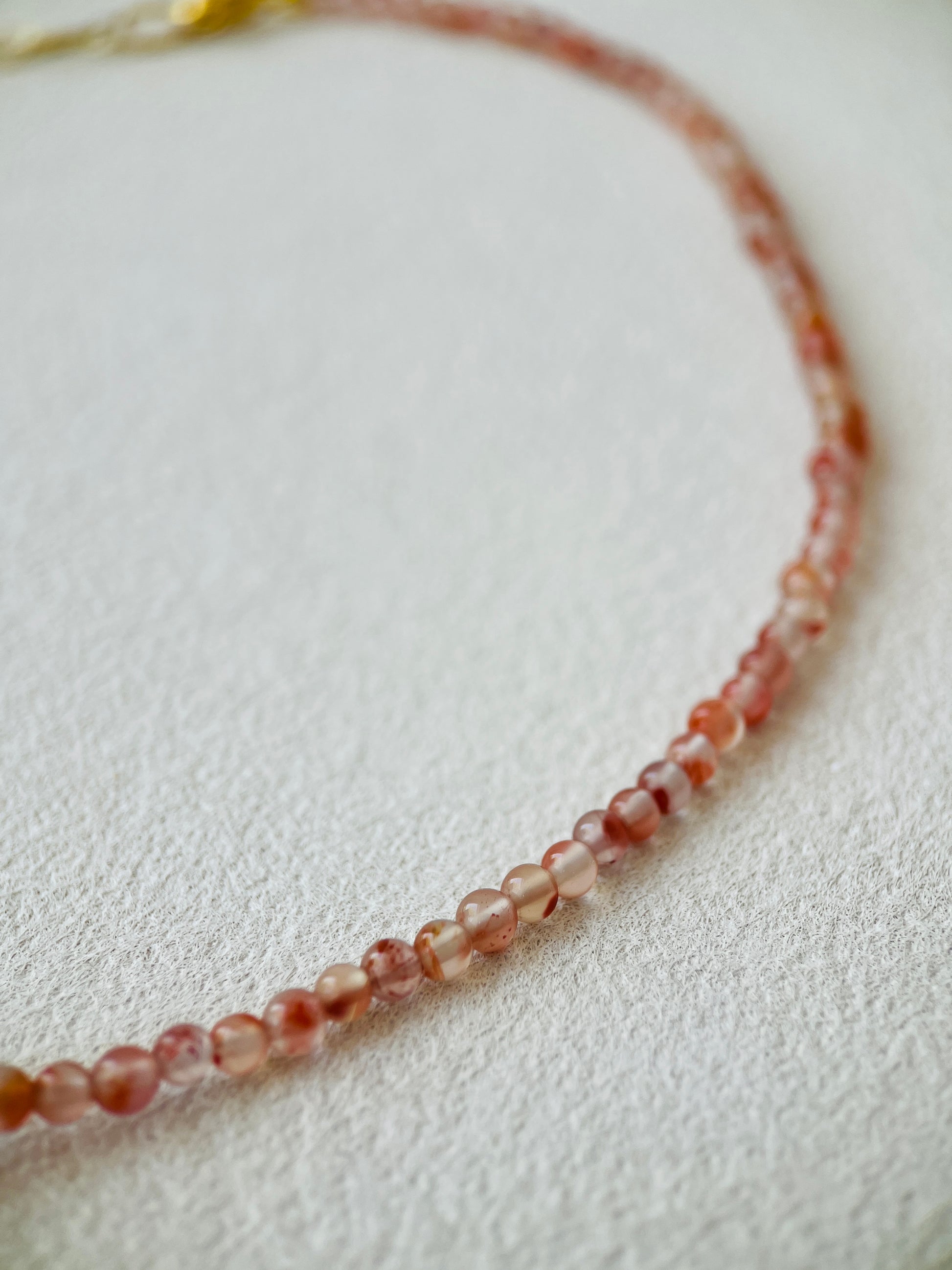 Red carnelian necklace on white background 