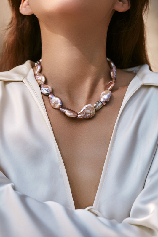 Pearl necklace worn by a person in a white outfit