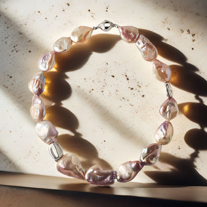 Pearl necklace with silver accents on a textured surface